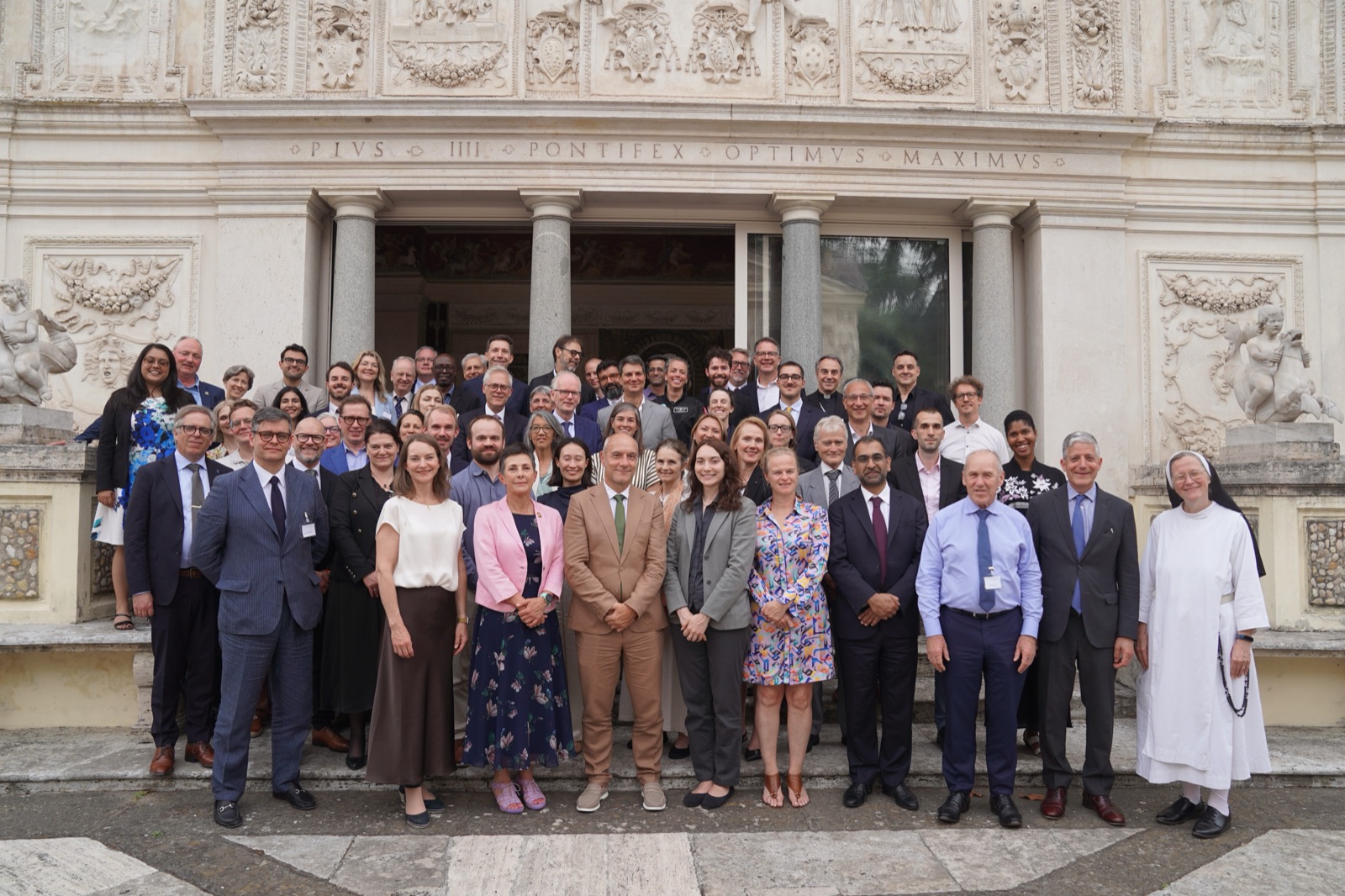 Workshop participants gathered on the steps of the Casina Pio IV, Vatican City, beneath the inscription PIVS IIII PONTIFEX OPTIMVS MAXIMVS.
